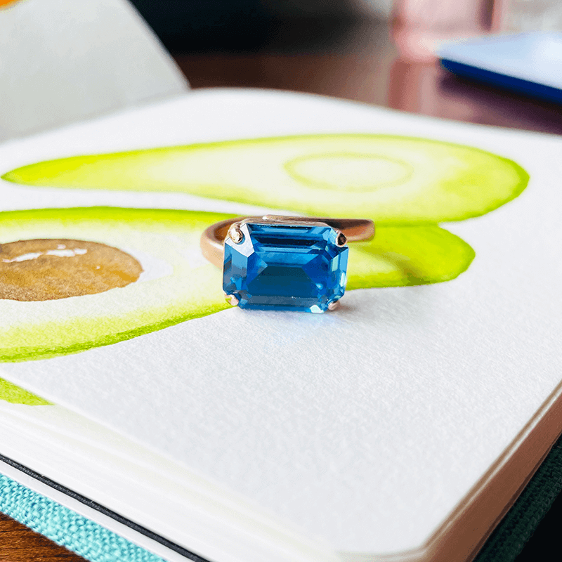 Swarovski Blue Ring, adjustable. Against a coloured background