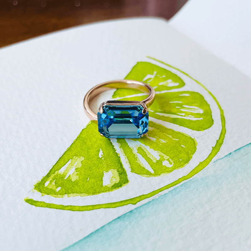 Swarovski Blue Ring, adjustable. against coloured backgroun