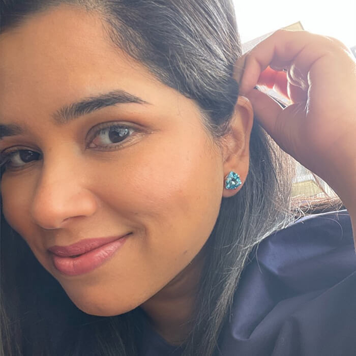 Aquamarine stud earrings with a blue swarovski set in rose gold on model