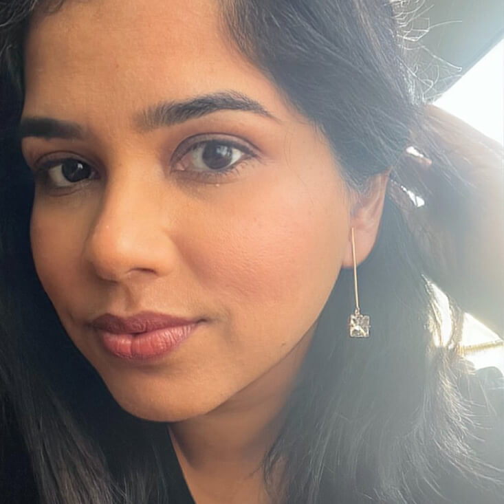 rose gold dangle earrings with clear Swarovski on model