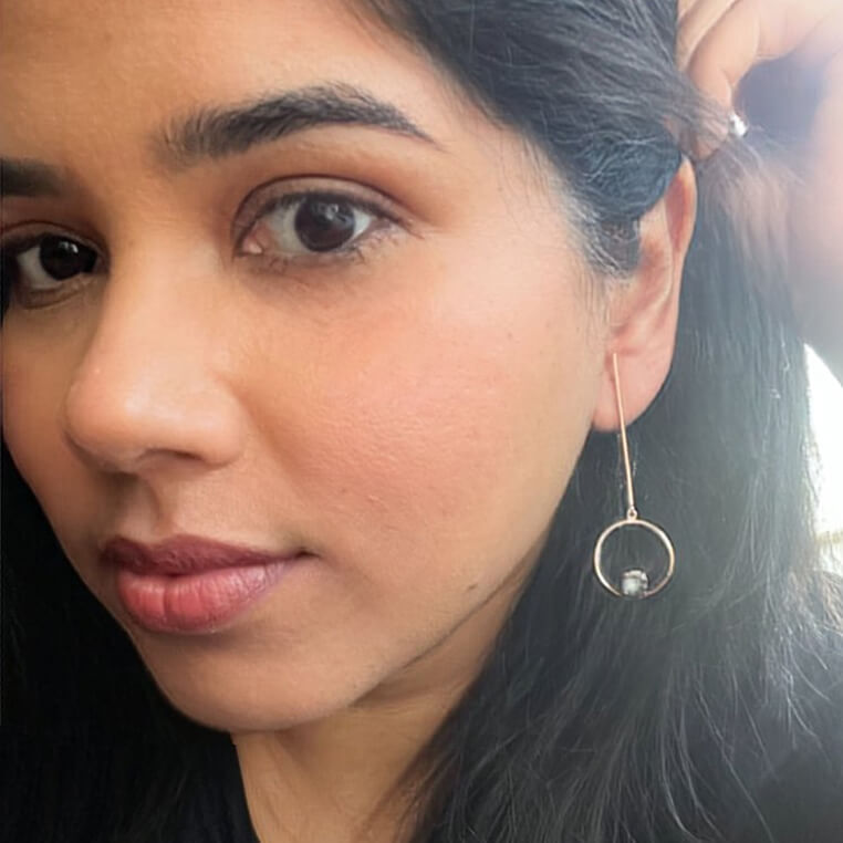 rose gold dangle earrings with grey Swarovski on model