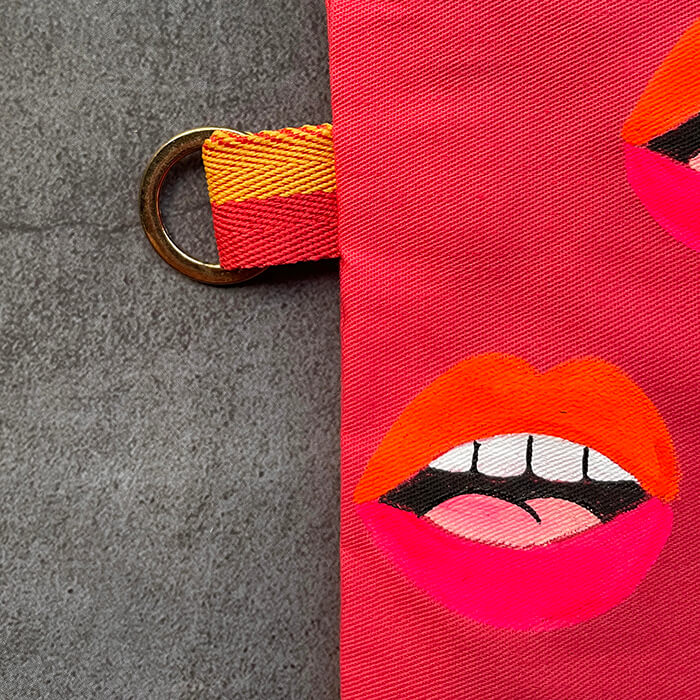 pink hand painted bag with lots of lips close up 