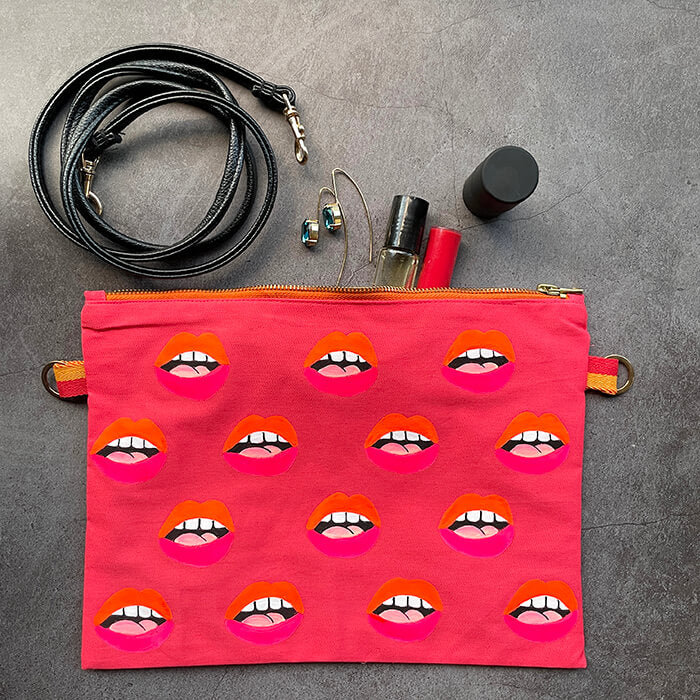 pink hand painted bag with lots of lips flatlay