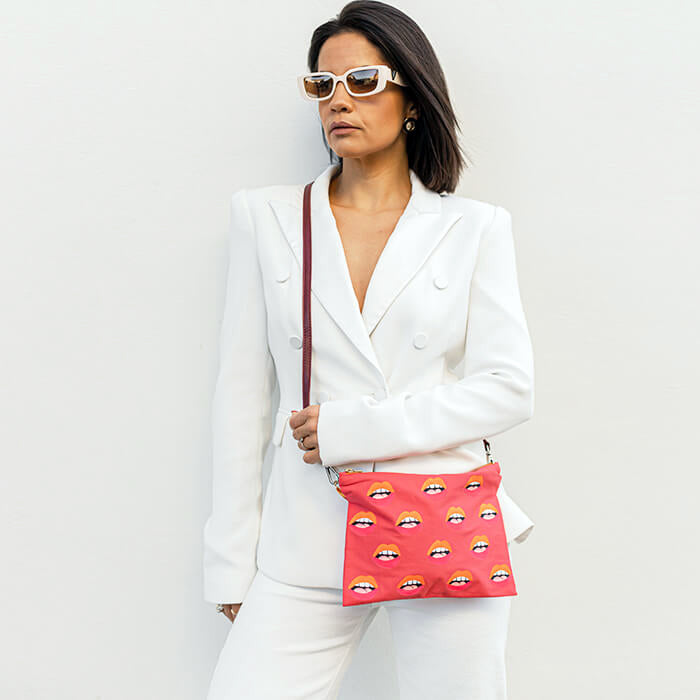 pink hand painted bag with lots of lips on model