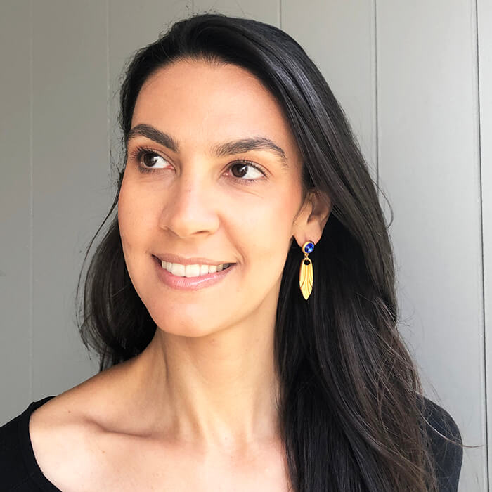 gold dangle earrings with blue swarovski crystal on model