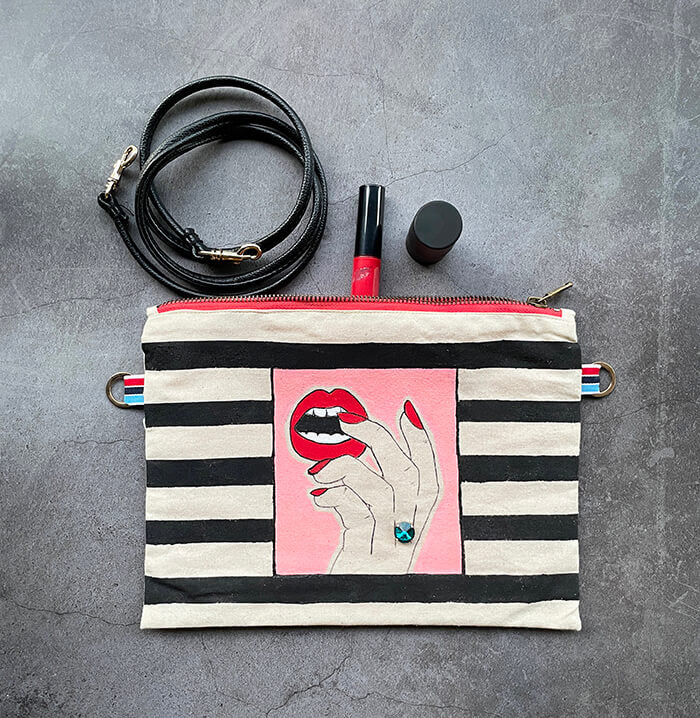 Hand painted Canvas Bag with fingers wearing a swarovski crystal biting teeth flat lay
